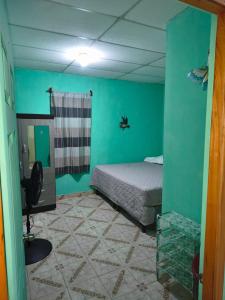 a bedroom with a bed in a room with green walls at Casa Luna in El Remate