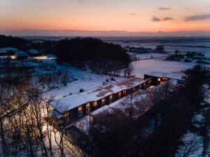 ein Zug mit eingeschalteten Lichtern im Schnee in der Unterkunft 瀾山ホテル LanshanHotel 澜山酒店 in Horonai