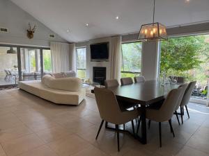 a dining room with a table and a couch at The Grand Oasis in Donvale