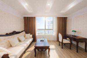 a living room with a couch and a table and a piano at Asean Hotel in Hải Dương