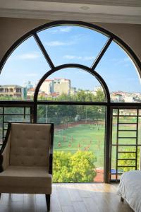 a bedroom with a large window with a view of a soccer field at Asean Hotel in Hải Dương