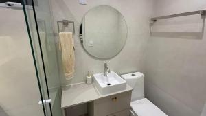 a bathroom with a sink and a mirror and a toilet at Conchas Lofty in Governador Celso Ramos +4 photos