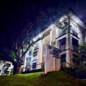 a white building with a tree in front of it at Skyline Abode Antipolo in Antipolo