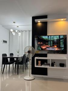a dining room with a table and a tv on a wall at Skyline Abode Antipolo in Antipolo