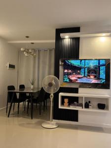 a dining room with a table and a television on a wall at Skyline Abode Antipolo in Antipolo