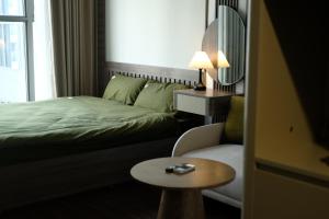 a bedroom with a bed and a chair and a table at A Quiet Stay - Service Apartment, Vinhome Ocean Park, Ha Noi in Gia Lâm Pho +71 photos