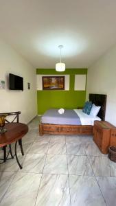 a bedroom with a large bed with a green wall at Hostal Mago in Tlaxcala de Xicohténcatl