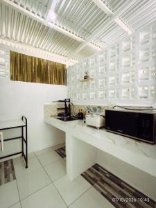 a kitchen with a counter with a microwave in it at Casa Marilag Guest House in Siquijor +13 photos
