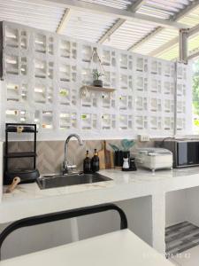 a kitchen with a sink and some white cabinets at Casa Marilag Guest House in Siquijor