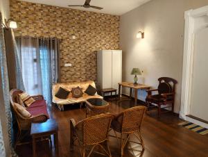 a living room with a couch and chairs at Raindrop Fort kochi in Cochin