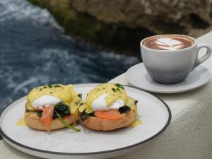 a plate with a sandwich and a cup of coffee at Naluna Lembongan in Nusa Lembongan
