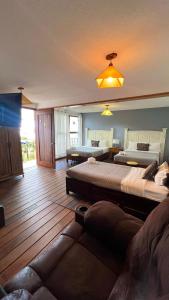 a large room with two beds and a couch at Hostal Mago in Tlaxcala de Xicohténcatl