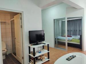 a living room with a flat screen tv and a bathroom at AvataraA B32 by malai in Ban Tha Fat