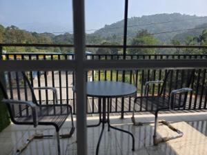 a table and two chairs on a balcony with a view at Dreamwagon hotel lakkidi in Vythiri