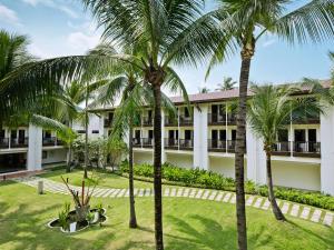 a building with palm trees in front of it at Hotel Ibis Samui Bophut in Bophut