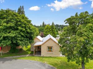 an old house with a white roof on a street at Naseby Apartments in Naseby