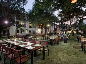a restaurant with tables and chairs in a park at night at Hotel Ibis Samui Bophut in Bophut
