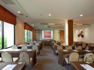 a restaurant with tables and chairs and a projection screen at Hotel Ibis Samui Bophut in Bophut 