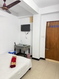 a room with a bed and a desk and a television at Hotel Rose International in Dhaka +31 photos