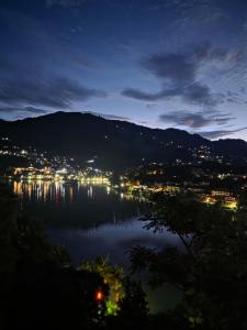 a view of a city and a lake at night at Pi Palace in Bhīm Tāl
