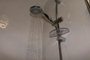a shower with a shower head in a bathroom at 2BR Apt By Eason Stays Short Lets Warrington in Warrington +25 photos