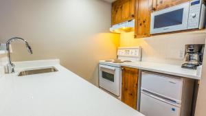 a kitchen with a sink and a stove top oven at Cahilty #247 in Sun Peaks