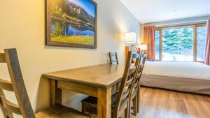 a room with a wooden table and a bed and a bedroom at Cahilty #247 in Sun Peaks