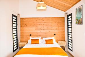 a bedroom with a bed with a wooden wall at Sagar Réunion in Saint-Paul +30 photos