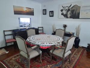 a dining room with a table and four chairs at 83 Ocean View in Port Shepstone +26 photos