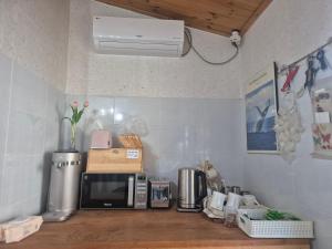 a kitchen counter with a microwave on a counter top at Adam Guesthouse in Gyeongju