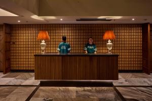 two people standing at a counter in a hotel lobby at The Passport Hotel in Assagao +26 photos