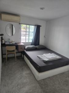 ein Schlafzimmer mit einem Bett und einem Schreibtisch mit Spiegel in der Unterkunft Phangan backpacker in Haad Rin