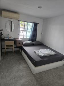 ein Schlafzimmer mit einem Bett, einem Schreibtisch und einem Spiegel in der Unterkunft Phangan backpacker in Haad Rin