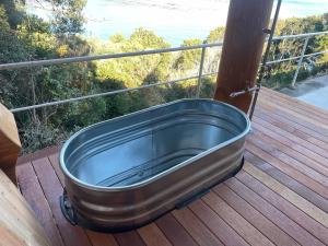 a metal bath tub sitting on a deck at 椿ハウス 海の見えるサウナ付き貸切別荘 in Anan