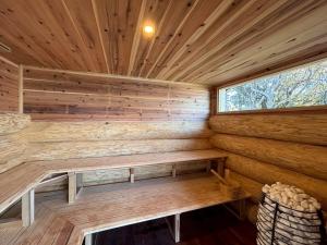 a sauna with a bench in a wooden cabin at 椿ハウス 海の見えるサウナ付き貸切別荘 in Anan