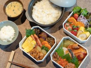 a group of bowls of food with rice and vegetables at Nature Base Hotel NUPPUKOTTE in Teshikaga