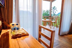 a table with two glasses and a bottle of water on it at Kubu Cemara Sidemen in Karangasem