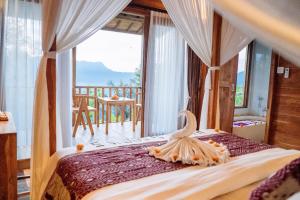 a bedroom with a bed with a view of the ocean at Kubu Cemara Sidemen in Karangasem +44 photos