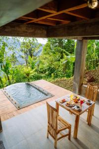 a patio with a table and chairs and a pool at Kubu Cemara Sidemen in Karangasem