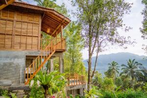 a tree house in the jungle with a balcony at Kubu Cemara Sidemen in Karangasem