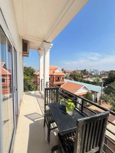 a porch with a table and chairs on a balcony at Grand Apsara Residence in Siem Reap