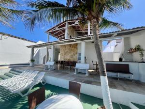 a villa with a swimming pool and a house at Casa La France in Caucaia