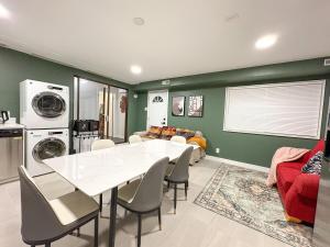 a dining room with a white table and a living room at Vancouver UBC 3BD Garden Suite in Vancouver