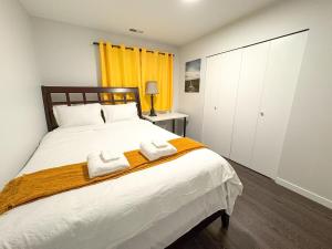 a bedroom with a bed with two towels on it at Vancouver UBC 3BD Garden Suite in Vancouver