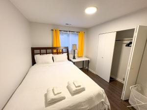 a bedroom with a bed with two towels on it at Vancouver UBC 3BD Garden Suite in Vancouver +5 photos