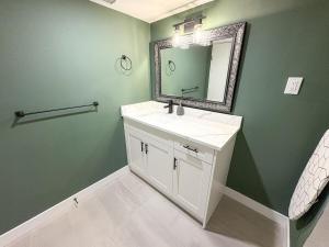 a bathroom with a white sink and a mirror at Vancouver UBC 3BD Garden Suite in Vancouver