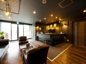 a living room with a fireplace and a bar at Hotel Areaone Naruto in Naruto
