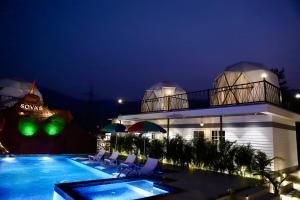 a resort with a swimming pool at night at Sovas Nature Hideout in Kolvan
