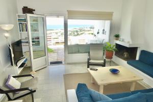a living room with a blue couch and a table at Villa Kamari in Kastraki