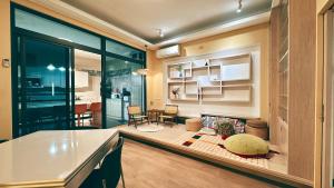 a kitchen with a counter and a living room at 禾夏民宿Her Shot Inn in Hengchun South Gate